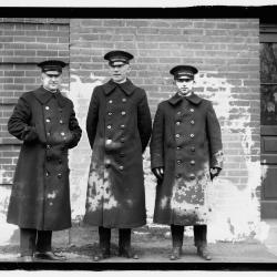 This black-and-white photograph of three White House chauffeurs was taken on December 27, 1919. Pictured from left to right: Francis H. Robinson, William Miller, and Edward White. White House chauffeurs served as drivers for the first family after automobiles were introduced to the White House during the William Howard Taft administration. Here, the chauffeurs are likely pictured outside the White House garage, formerly the White House stables.